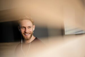 Close up photo of young happy man in earphones