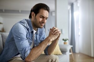 Young sad man crying at home.